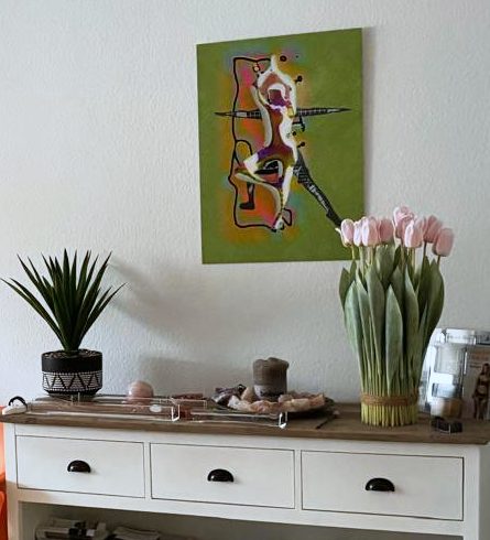 Empfang: Sideboard mit Grünpflanze und Tulpen, darüber ein farbiges Bild